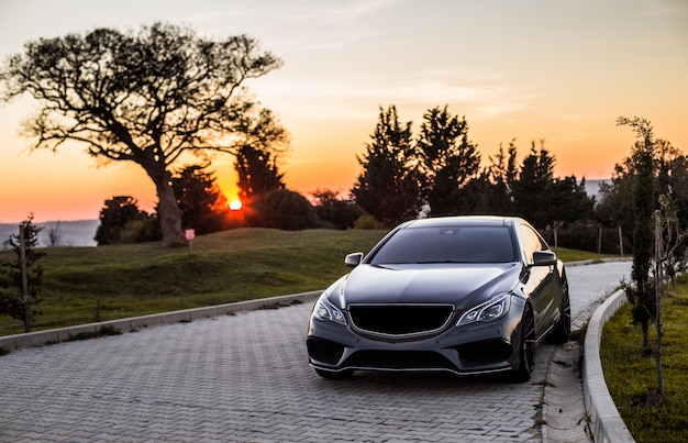 grey-luxury-sedan-car-sunset_114579-4045